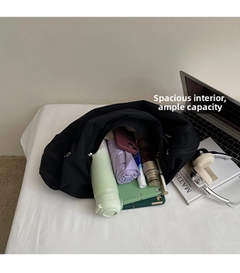 Interior view of large black canvas tote bag filled with daily essentials for commuting