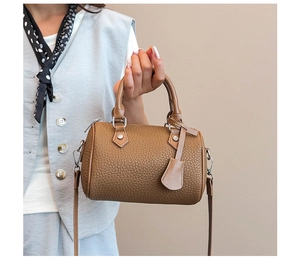 Close-up of brown litchi leather Boston bag with silver hardware and adjustable strap