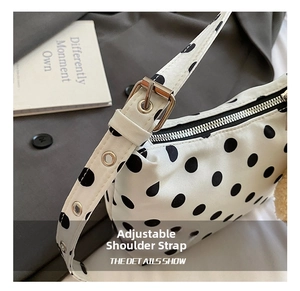 Detail of adjustable shoulder strap with silver metal buckle on polka dot bag