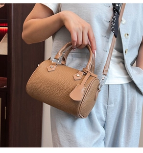Detail view of caramel litchi grain leather Boston bag with handles and hooks