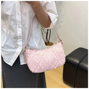 Close-up of pink denim underarm bag featuring frayed diamond pattern and chic design.