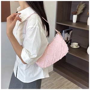 Detail view of stylish pink denim crescent underarm bag with frayed diamond grid texture