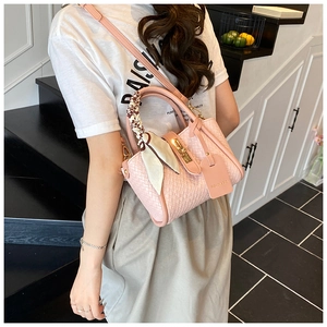 Pink woven bucket bag featuring metal twist lock closure and silk scarf handle detail