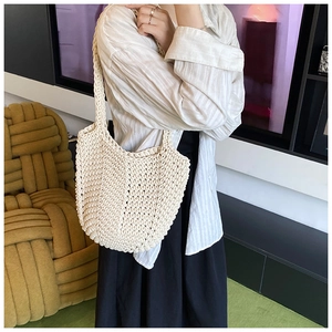 Detail shot of a beige woven tote bag showing the textured cotton rope material and strap