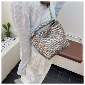 Sac fourre-tout tissé argenté sur modèle soulignant sa grande taille et son style décontracté