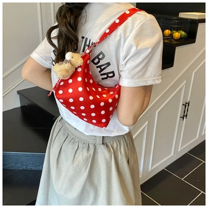 Rote Polka-Dot-Schultertasche mit Bärenanhänger an einem Model im täglichen Gebrauch