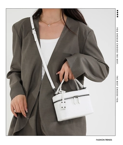 Detail of white crocodile pattern small square handbag with adjustable strap and zipper