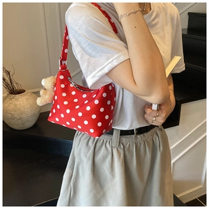 Red mini shoulder bag with white polka dots featuring a cute plush bear charm on a model
