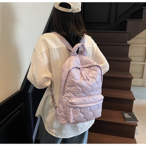 Close-up of lilac quilted backpack with rhombus stitching and rope zipper detail