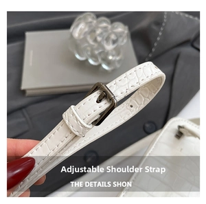 Detail of adjustable white crocodile texture strap with dark grey metal buckle