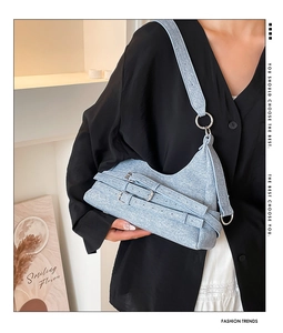 Détail du sac hobo en jean bleu clair doté de trois boucles argentées réglables élégantes