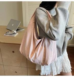 Close-up of pink large capacity tote bag featuring wrinkled nylon fabric and zipper detail