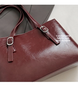 Detail of soft dark red waxed leather shoulder bag with vintage silver metal buckle