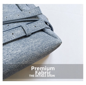 Gros plan du sac demi-lune en denim bleu avec tissu de qualité et boucle métallique