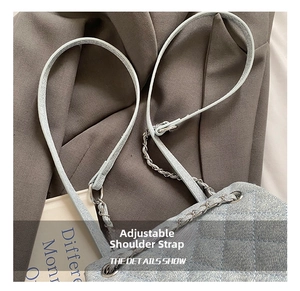 Detail of light blue quilted backpack with adjustable silver chain and leather strap