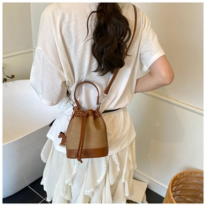 Vue détaillée du sac seau en toile avec garniture en cuir marron et cordon serrage
