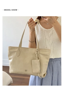 Close-up of cream large tote bag with a matching hanging coin purse on the shoulder strap