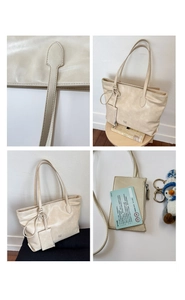 Detail view of beige tote bag with ear logo, small coin purse, and penguin keychain