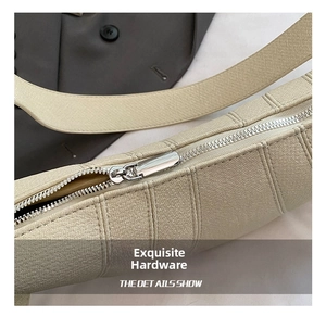 Close-up of silver metal zipper and lychee texture on a beige shoulder bag