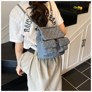 Quilted denim backpack featuring silver chain straps and magnetic pockets on model