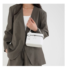 White faux-crocodile textured handbag styled with a grey suit on a fashion model