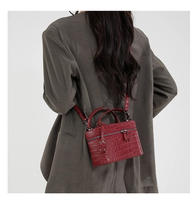 Model wearing a burgundy crocodile texture mini handbag with crossbody strap