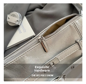Makroaufnahme der silbernen Metallic-Ledertextur und Reißverschluss-Detail der Schultertasche