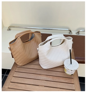 Detailed V-shaped woven pattern on light brown and white tote bags with thick leather handles