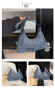 Détail du sac croissant en denim bleu foncé avec plusieurs sangles à boucle et métal argenté