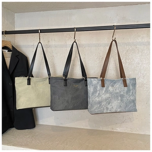 Detailed close-up of textured tote bags in olive green, dark grey, and stone blue colors