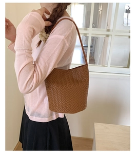Detailed view of brown woven hobo bag showing intricate V-shape texture and strap