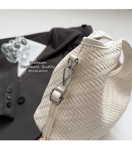 Detailed view of white woven texture and premium silver metal hardware on handbag