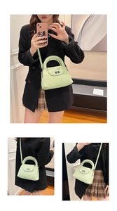 Dettaglio della borsa a pieghe verde chiaro con chiusura argento e tracolla su modella