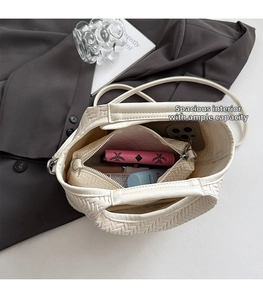 Top view of cream woven bucket bag interior showing spacious capacity with inner pouch
