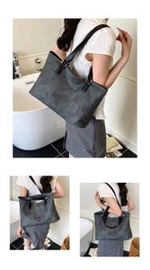 Detailed view of the large grey retro tote bag with black straps and golden brand lettering