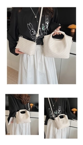 Detail view of white woven bucket bag set with silver metal buckles and shoulder strap