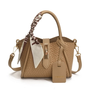 Khaki woven bucket bag with metal clasp and houndstooth scarf on white background