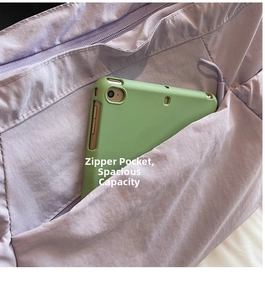 Detail view of the spacious front zipper pocket on a lavender tote bag with an iPad