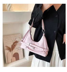 Gros plan du sac sous le bras en denim rose avec plusieurs boucles et détails argentés