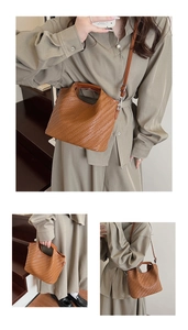 Close-up of brown woven leather texture and elegant handle on a chic crossbody bag
