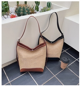 Gros plan de sacs seaux en paille tressée noir et marron avec finitions et bandoulières en cuir