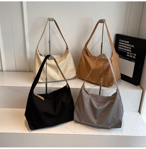 Dettaglio di borse tote in tela minimaliste in quattro colori su supporto in marmo