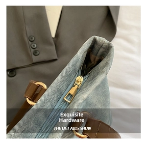 Detail of premium golden metal zipper and high-quality leather handles on denim tote bag