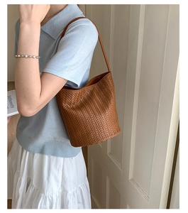 Close-up of retro woven bucket bag with thick herringbone texture and leather shoulder strap