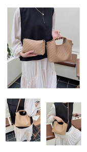 Detail of warm khaki woven tote set with herringbone texture and matching pouch