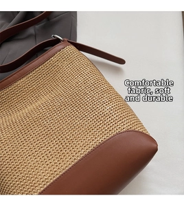 Detail of hand-woven straw bag with premium brown leather base and matching shoulder strap