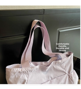 Detail view of light purple canvas tote bag featuring reinforced handles and side pockets