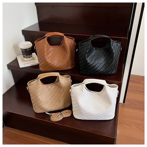 Detail view of woven leather tote bags in four colors with adjustable shoulder straps