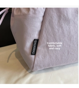 Macro shot of light purple nylon tote bag stitching and branded woven label detail