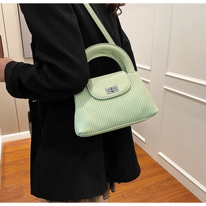 Detail of light green pleated bucket bag with lychee texture and metal twist lock